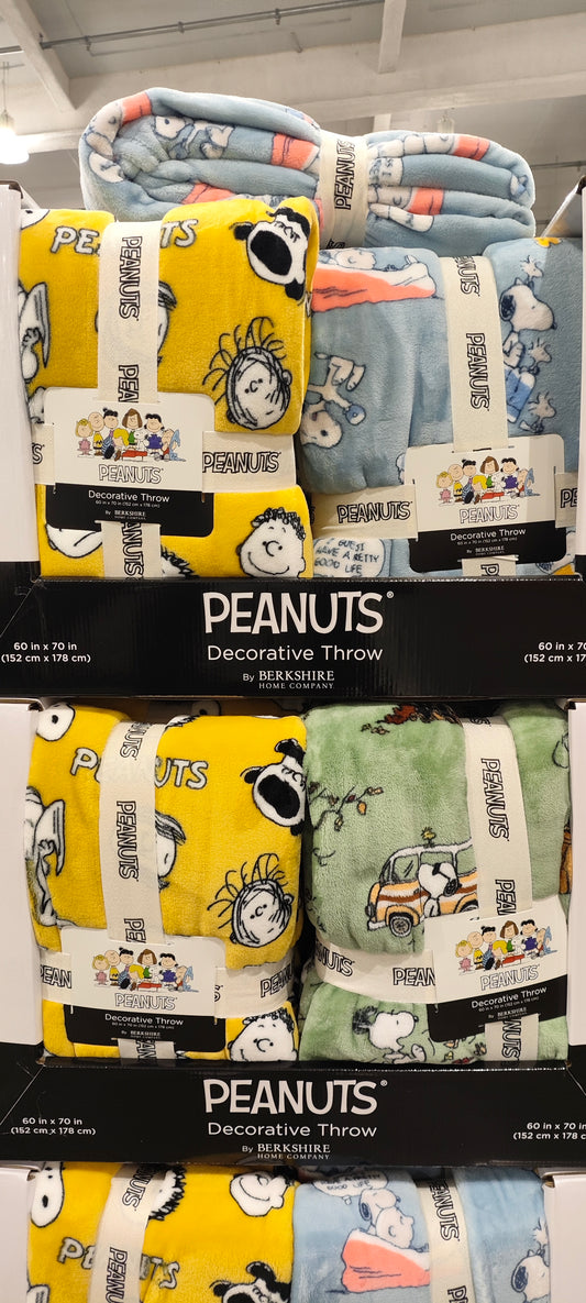 Peanuts-themed decorative throws on a store shelf